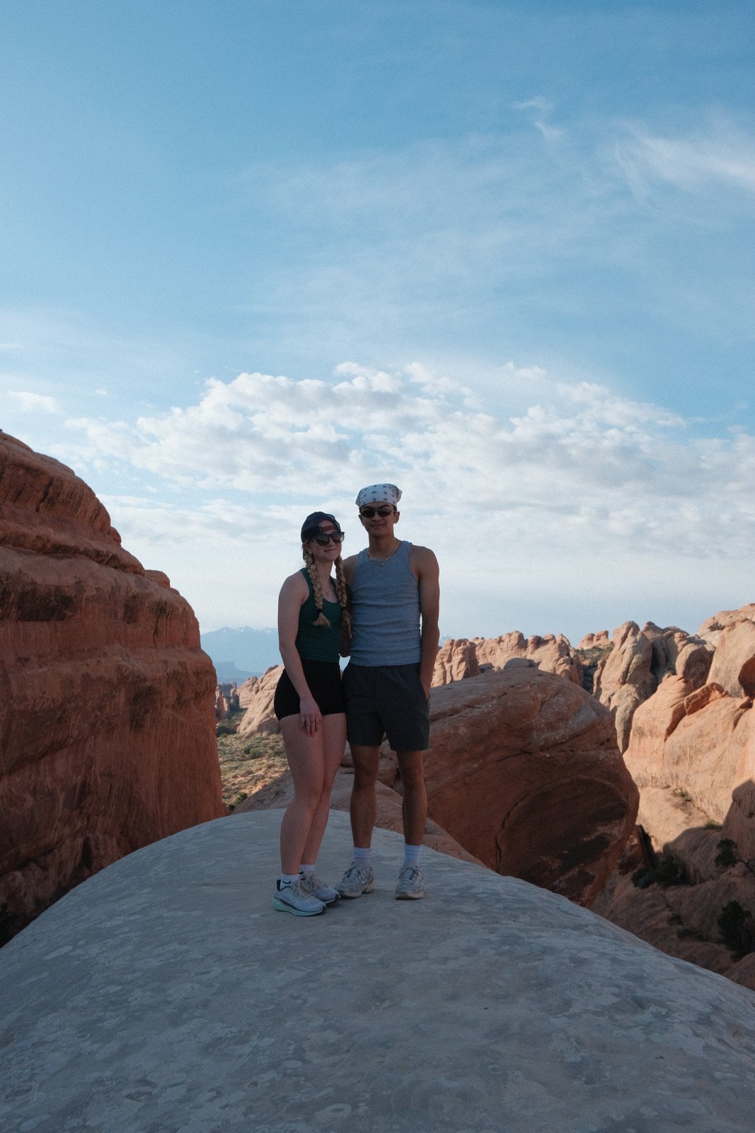 Ratanon and a friend on a rock formation in Arches National Park