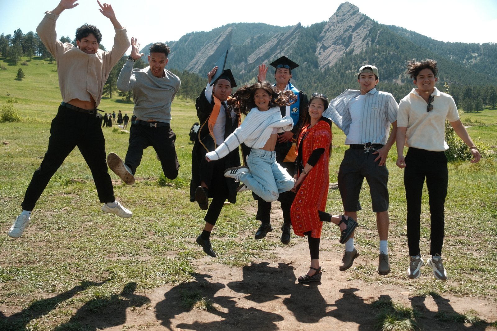 Ratanon jumping with friends in front of the Flatirons