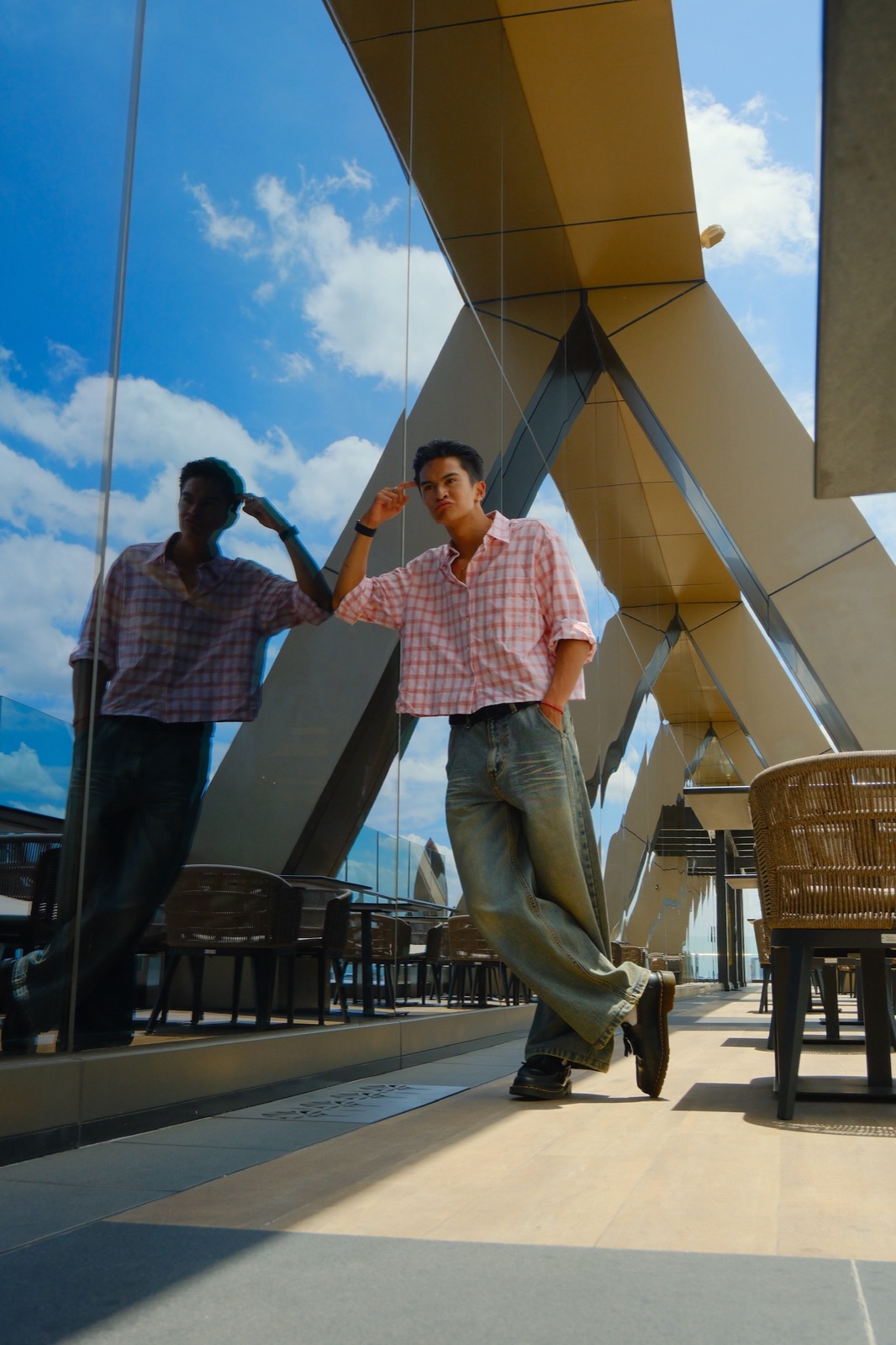 Ratanon in a cropped check shirt, rooftop portrait